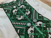 Traditional Ukrainian embroidered shirt for boys with green cross-stitch pattern and buttons, made from natural linen fabric.