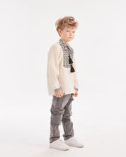 Boy wearing Ukrainian embroidered shirt, Slavic folk style, with jeans and sneakers, showcasing traditional ethnic fashion.