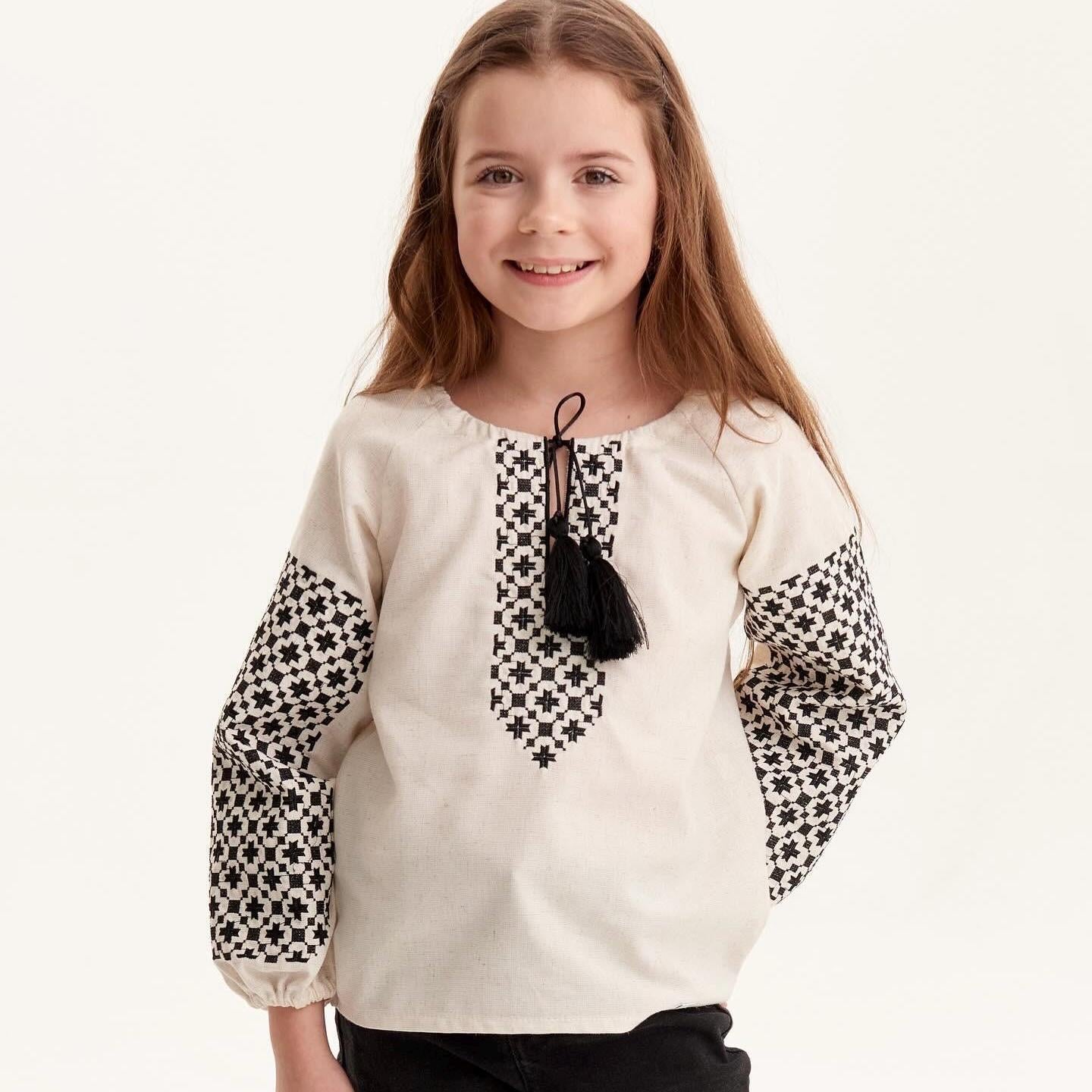 Ukrainian embroidered shirt for girls with black and white Slavic folk patterns, showcasing cultural elegance and vibrant design.