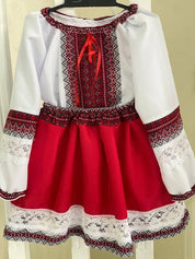 Traditional Ukrainian embroidered girl's blouse and skirt in red and white with intricate patterns, showcasing ethnic fashion.