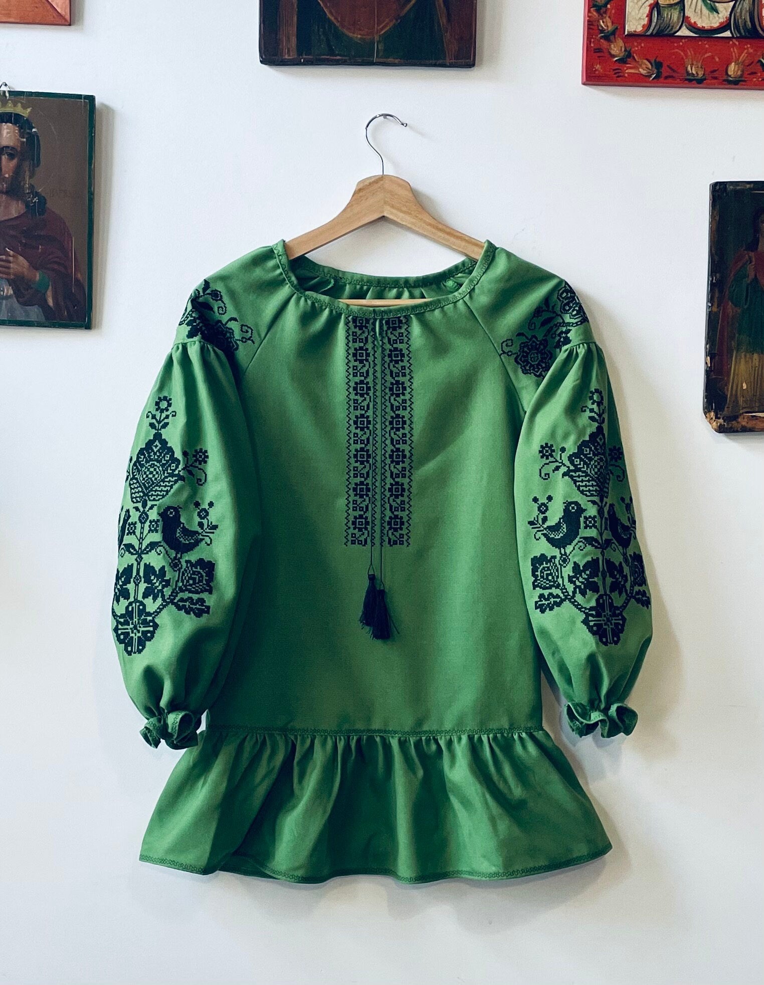 Green Ukrainian embroidered dress with black floral patterns, Vyshyvanka Boho style, featuring long sleeves and a tassel accent.