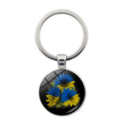 Ukrainian glass keychain with blue and yellow sunflower emblem, showcasing cultural pride and craftsmanship.