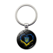 Ukrainian glass keychain with heart and emblem design, showcasing national pride and cultural heritage.