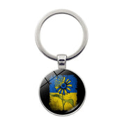 Ukrainian glass keychain featuring a sunflower emblem on a blue and yellow background, symbolizing national pride and heritage.