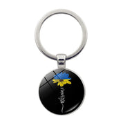 Ukrainian glass keychain with blue and yellow emblem, showcasing cultural pride and style.