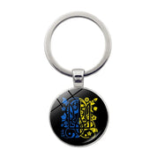 Ukrainian glass keychain with blue and yellow emblem, showcasing pride in Ukrainian heritage and culture.