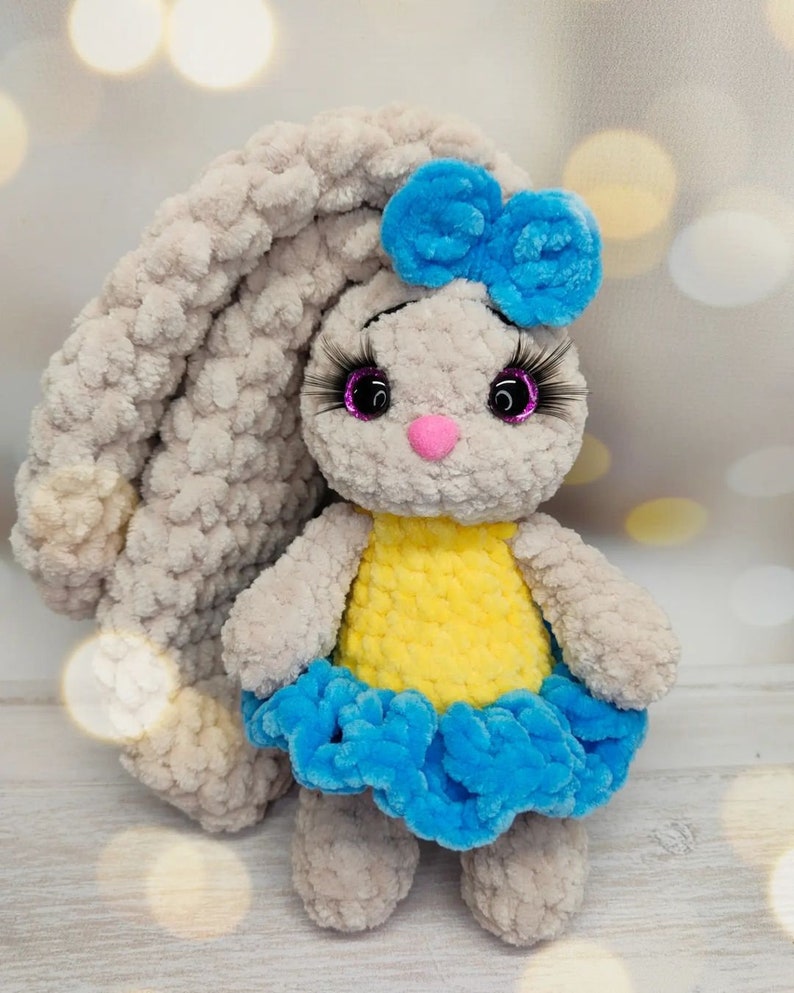 Handmade crochet bunny in Ukrainian flag colors, plush toy with blue and yellow outfit, symbol of peace from Ukraine.