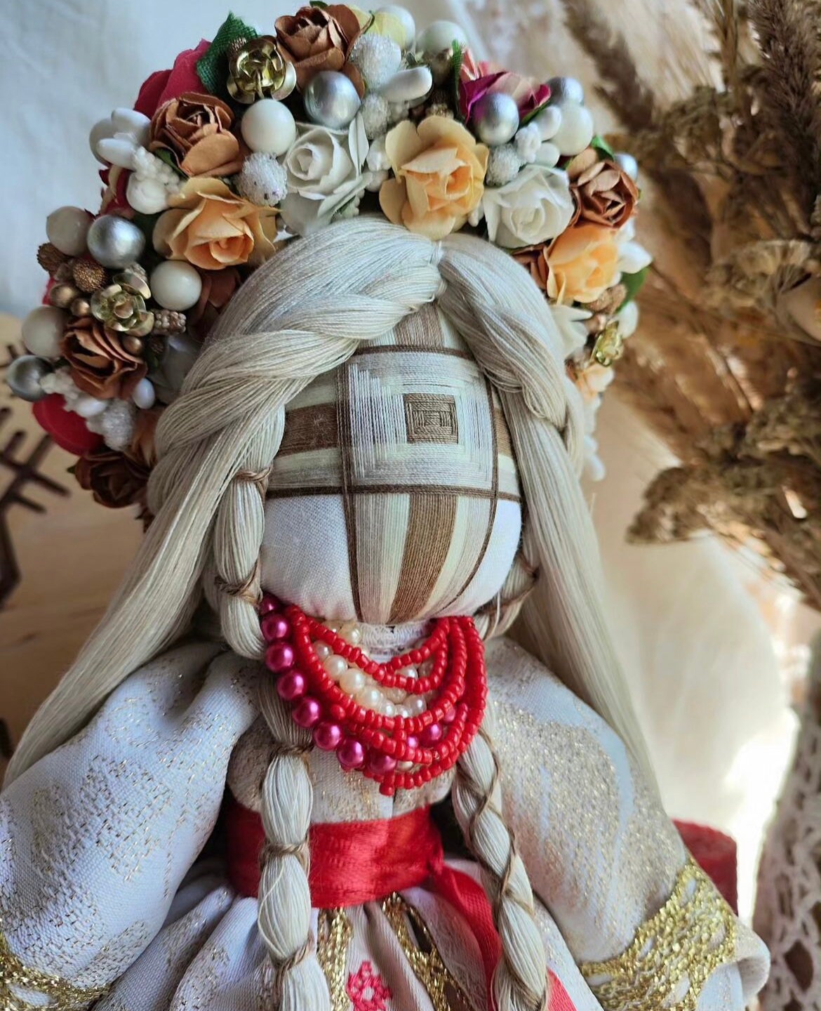 Handmade Ukrainian Motanka doll with traditional floral headpiece and embroidered dress, symbolizing protection and prosperity.