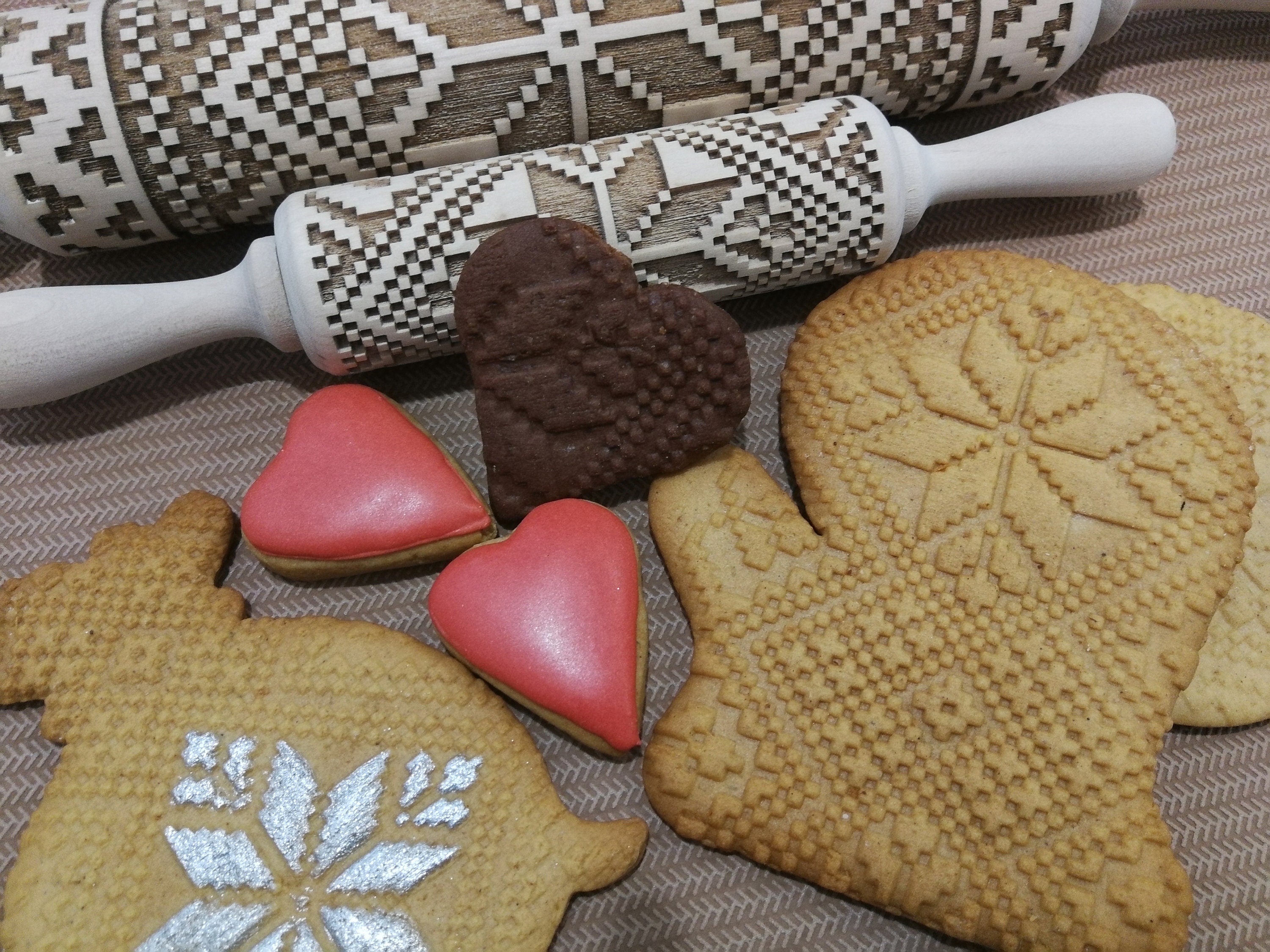 Laser-engraved rolling pin with Ukrainian folk patterns and embossed cookies, showcasing intricate designs for unique baking experiences.