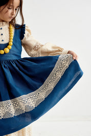 Blue Ukrainian linen dress for baby girl with lace trim and puff sleeves, featuring a traditional boho style.