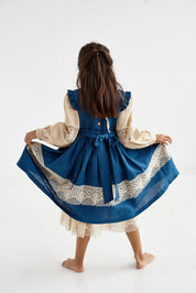 Alt Tag: Blue Ukrainian linen dress for baby girl with lace trim and puff sleeves, featuring a decorative belt and button details.