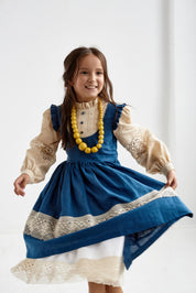 Alt Tag: Girl wearing a blue Ukrainian linen Vyshyvanka dress with lace trim and long puff sleeves, perfect for special occasions.