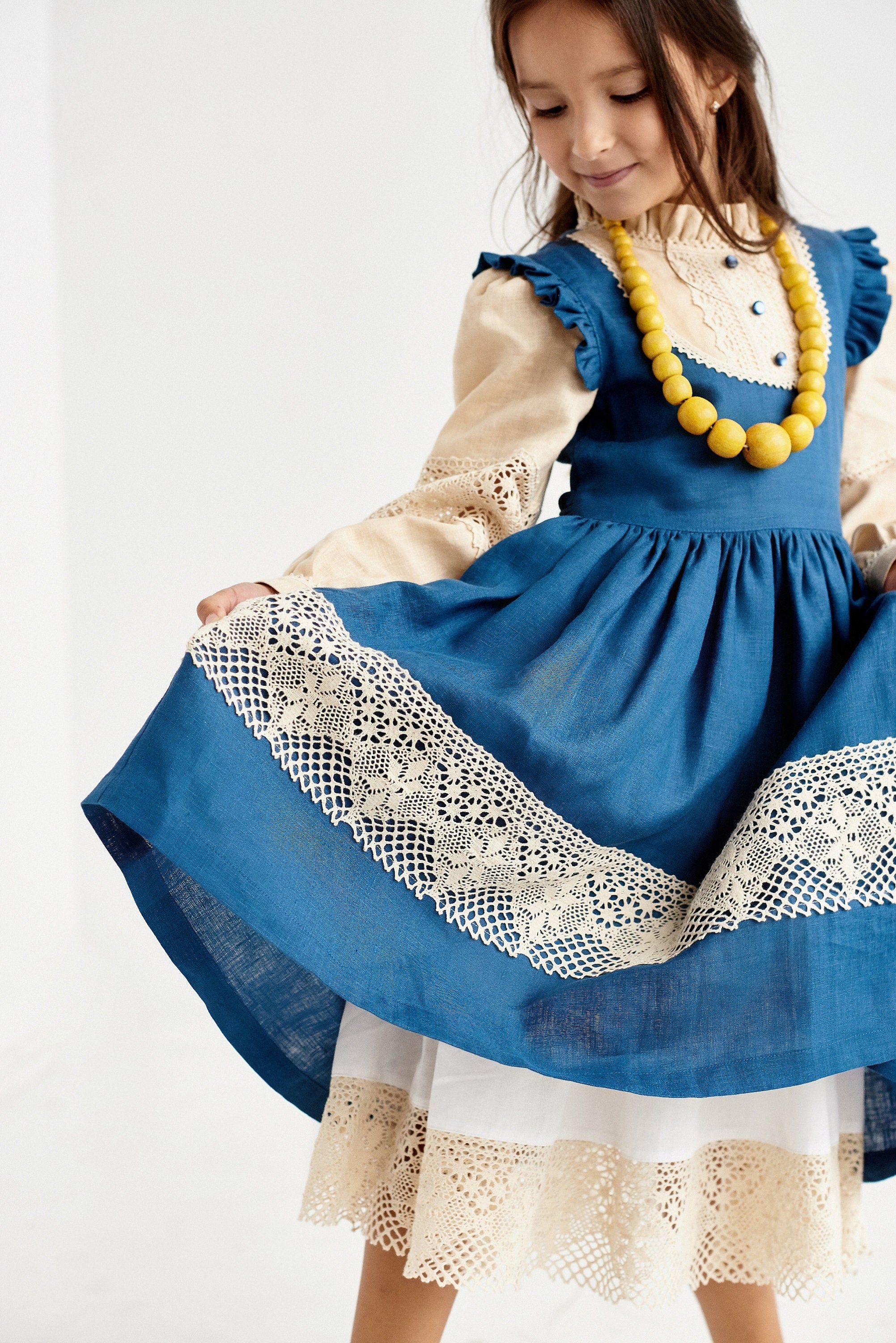 Blue Ukrainian linen dress for baby girl with lace trim and puff sleeves, perfect for special occasions and elegant style.
