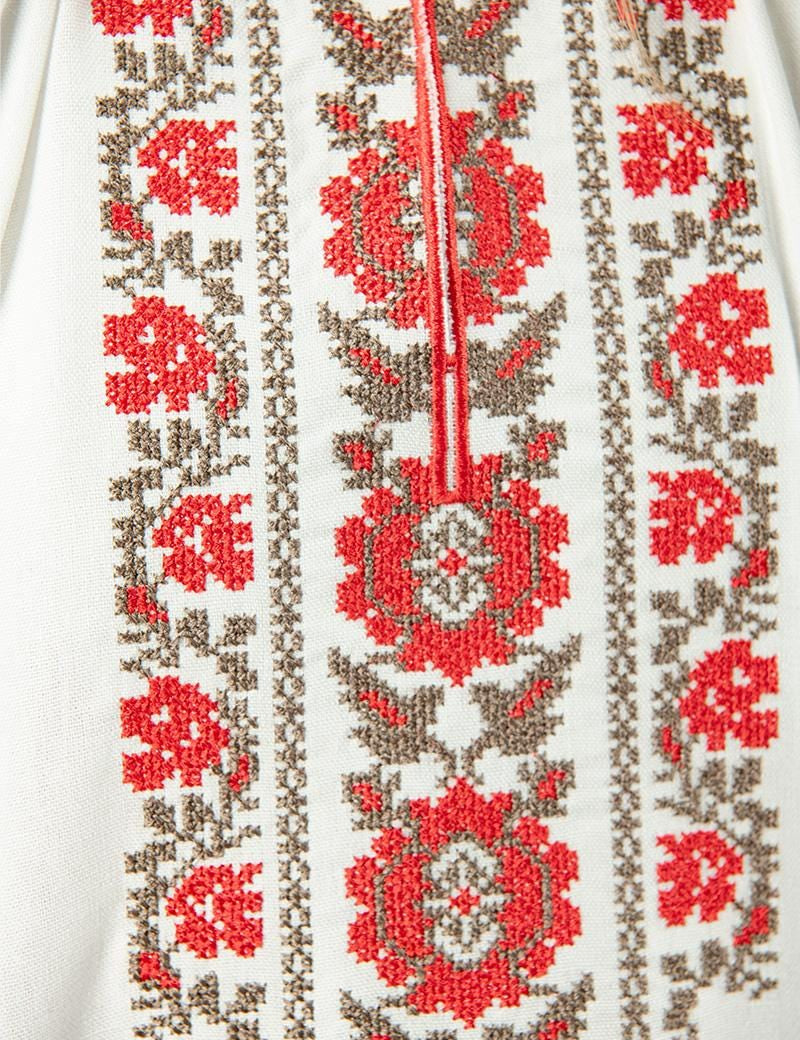Ukrainian linen shirt with ethnic floral embroidery in milk color, showcasing traditional red and beige designs for girls.