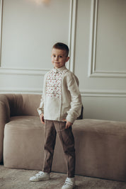 Boy wearing traditional Ukrainian embroidered linen shirt with long sleeves in a stylish setting.