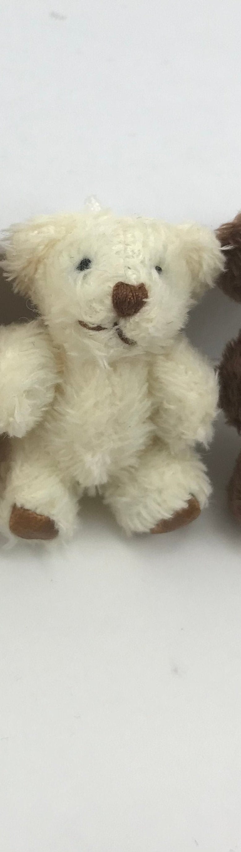 Hand-sewn miniature teddy bear with moveable arms and legs, made from soft fuzzy fabric, perfect for hanging as a cute decoration.