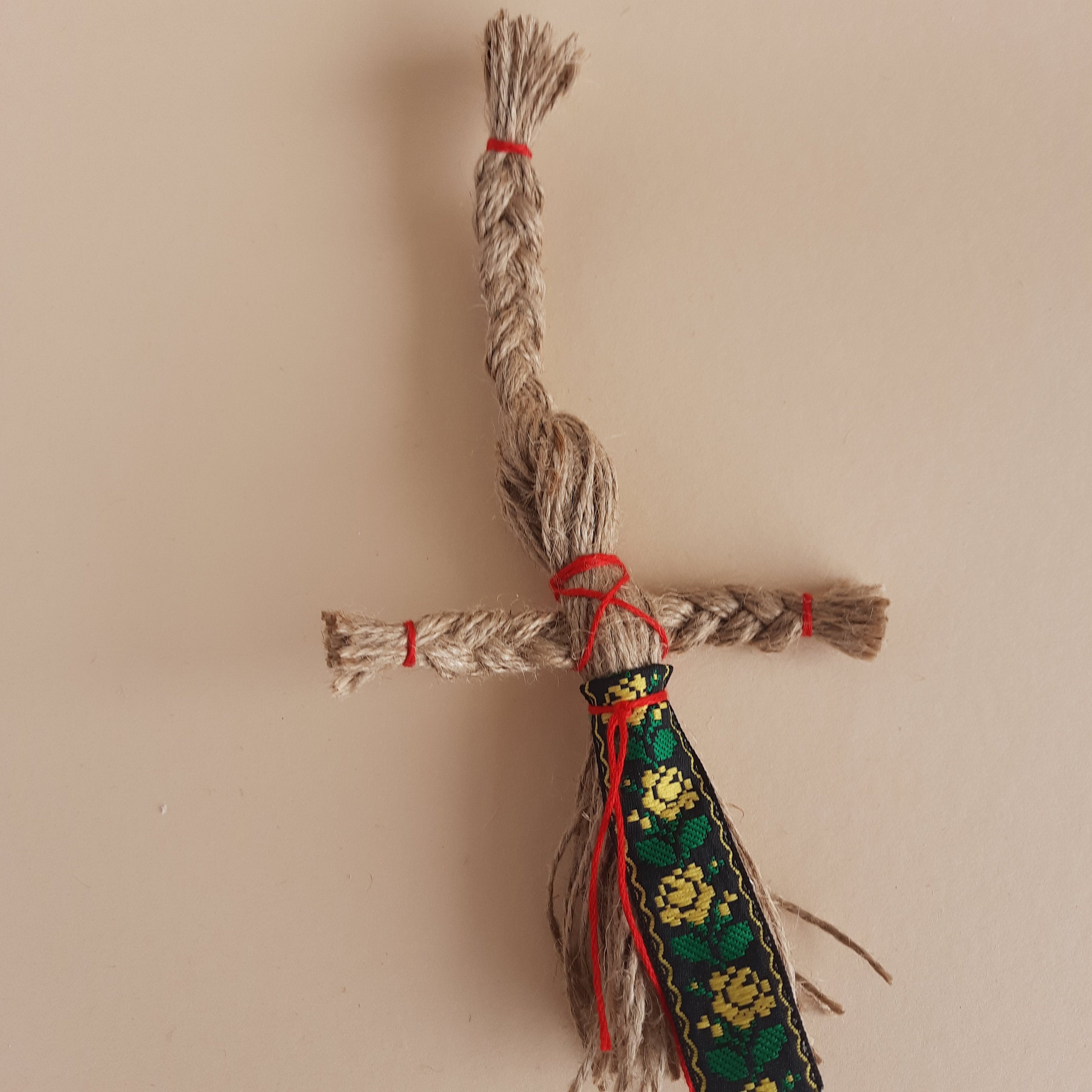 Miniature handmade Motanka doll with jute twine and colorful ribbon, traditional Ukrainian folk art and home decor collectible.