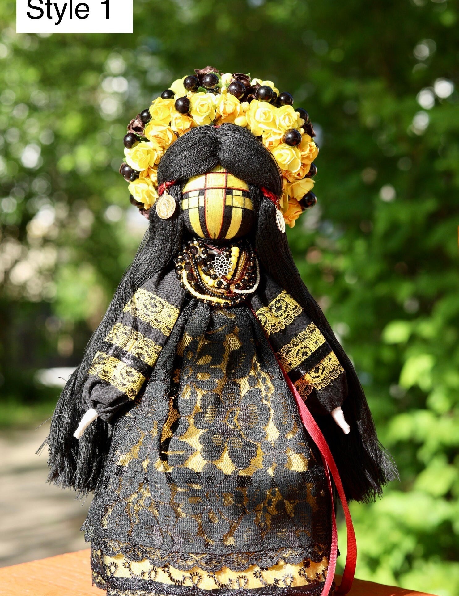 Handmade Ukrainian Motanka Doll in black and gold dress outdoors