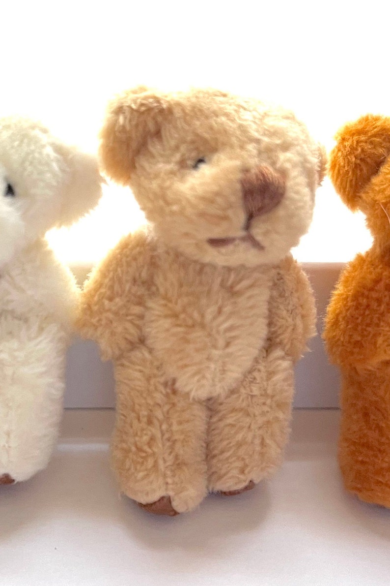 Tiny soft fuzzy stuffed teddy bears in cream, beige, and brown, with moveable arms and legs, perfect for hanging decorations.