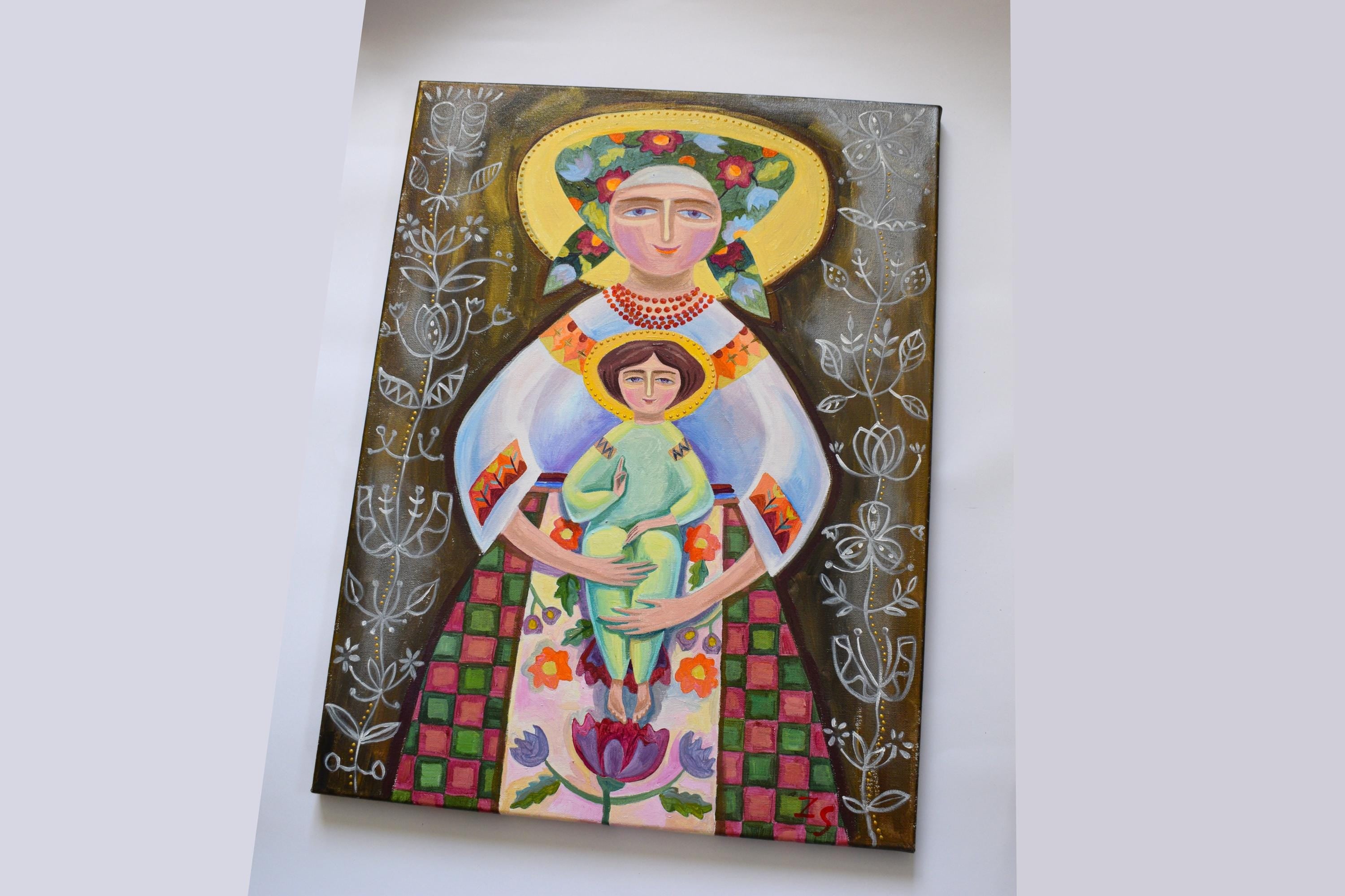 Ukrainian folk art painting of Virgin Mary with Jesus, featuring traditional clothing and embroidery, rich in cultural motifs.