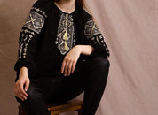 Woman wearing handmade embroidered blouse in boho ethno style with intricate Ukrainian Vyshyvanka design.