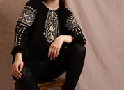 Woman wearing handmade embroidered blouse in boho ethno style, embodying modern Ukrainian Vyshyvanka fashion.