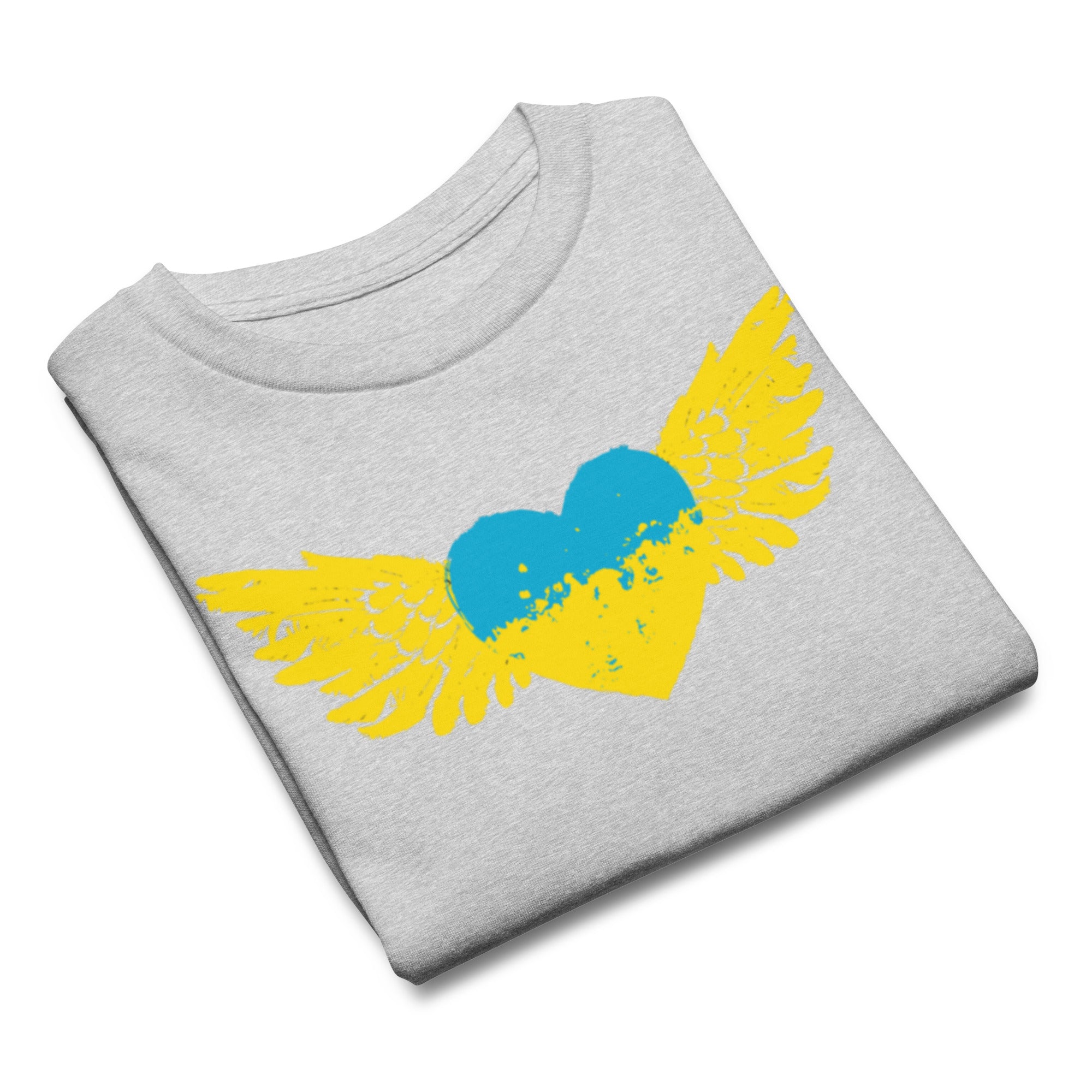 Youth T-shirt with blue and yellow heart and wings design inspired by Ukrainian flag, folded neatly on grey background.
