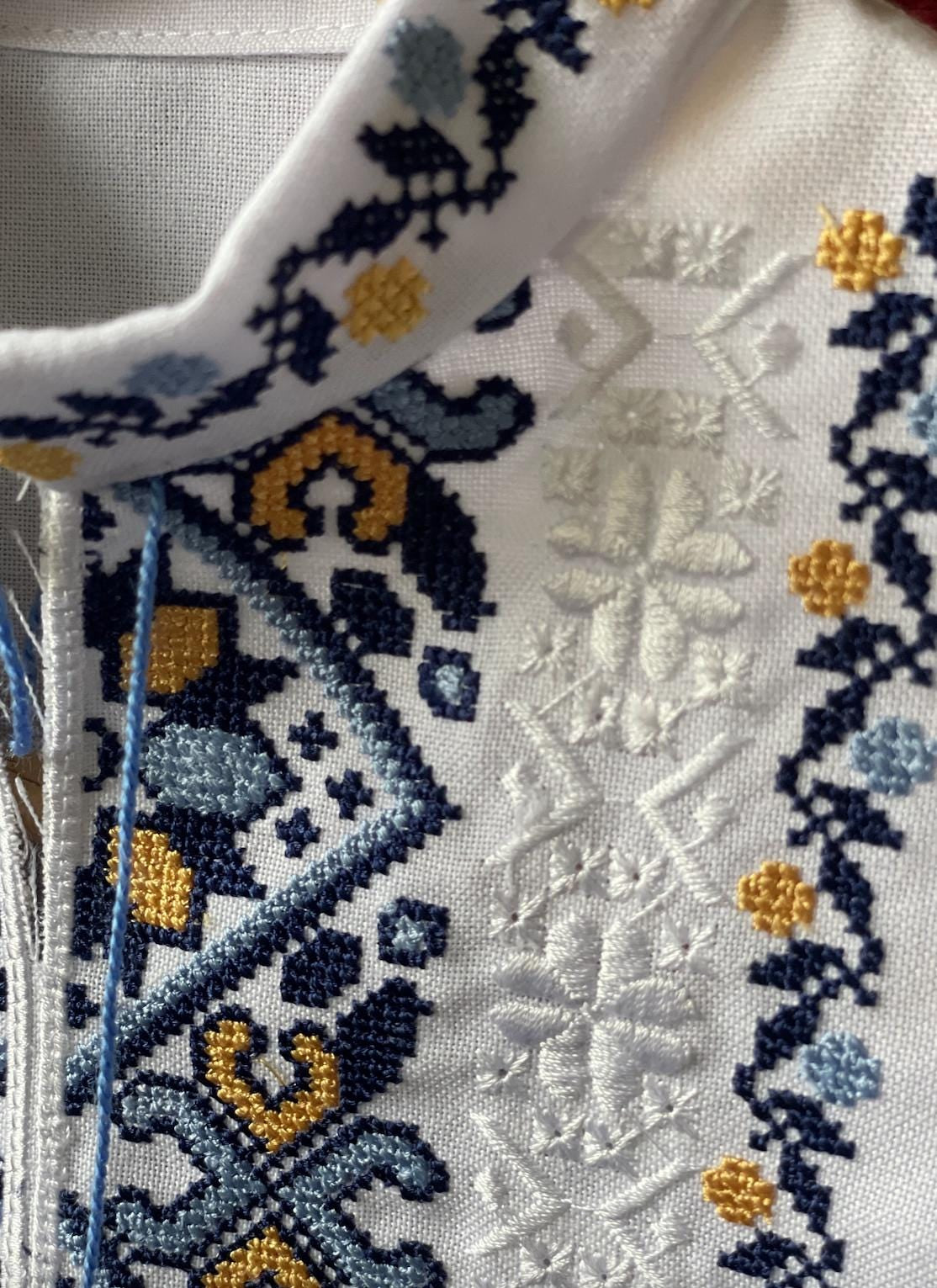 Close-up of boys' embroidered Ukrainian vyshyvanka shirt with blue and yellow Tryzub design