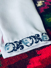 Close-up of embroidered sleeve detail on a Ukrainian boy's vyshyvanka shirt, showcasing traditional cross-stitch patterns.
