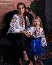 Mother and daughter in Ukrainian embroidered blouses, showcasing traditional Vyshyvanka with vibrant floral cross-stitch designs.