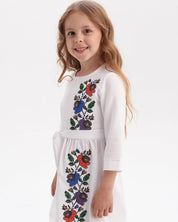 Girl in Ukrainian embroidered dress with floral design, traditional kids' vyshyvanka style.
