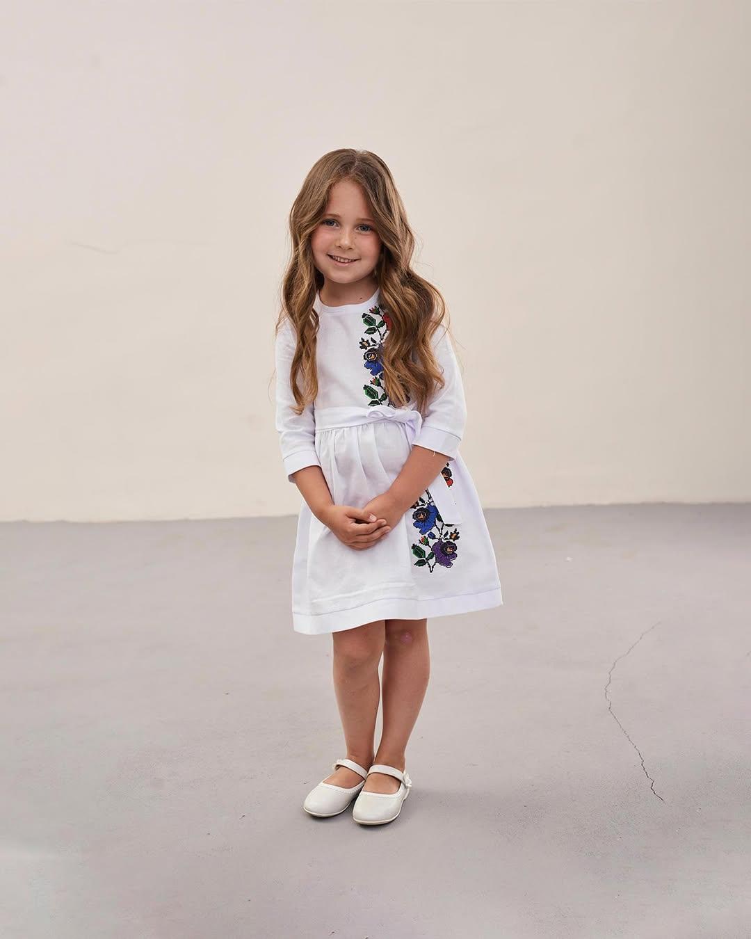 Young girl wearing a Ukrainian embroidered dress with floral patterns, traditional vyshyvanka style for cultural celebrations.