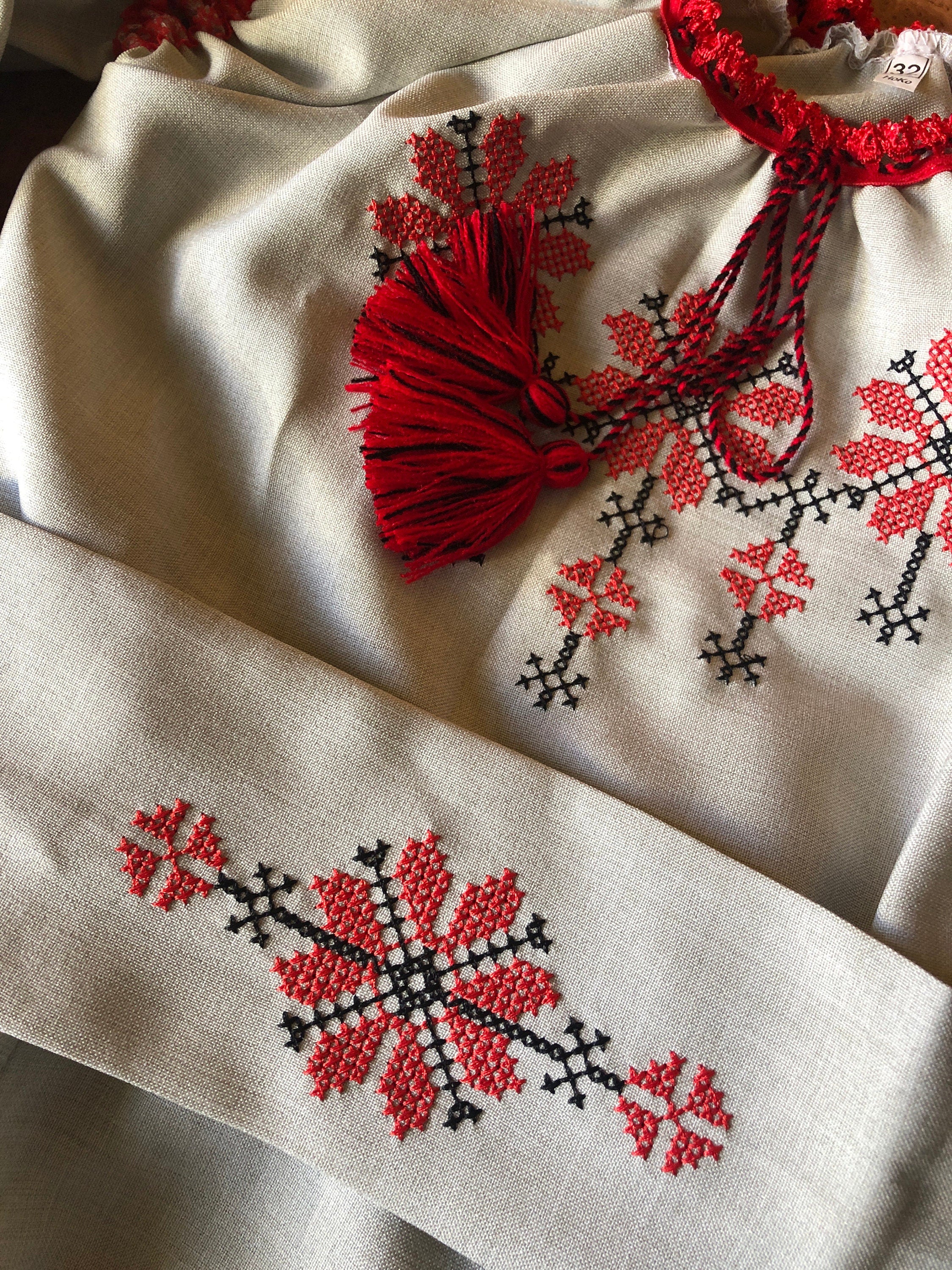 Ukrainian embroidered linen dress for girls with red Rosava motif and belt, showcasing traditional style and intricate floral design.