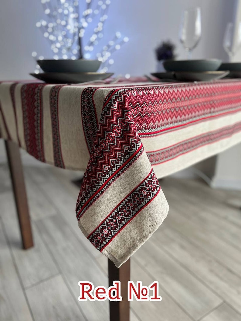 Ukrainian embroidered linen tablecloth with ethnic patterns on a dining table, 100% natural fabric, red design.