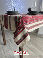 Ukrainian embroidered linen tablecloth with ethnic patterns on a dining table, 100% natural fabric, red design.