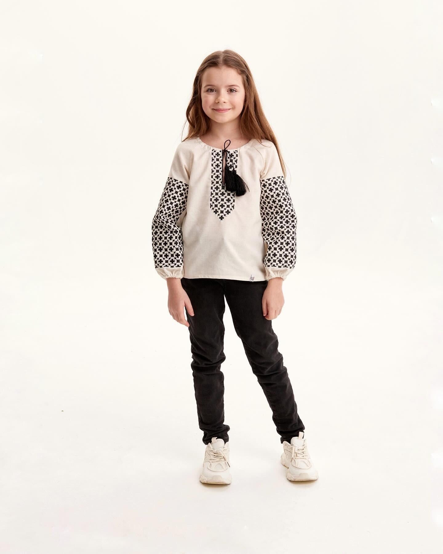 Girl wearing Ukrainian embroidered vyshyvanka shirt with Slavic folk art design, black and white patterns, cultural clothing