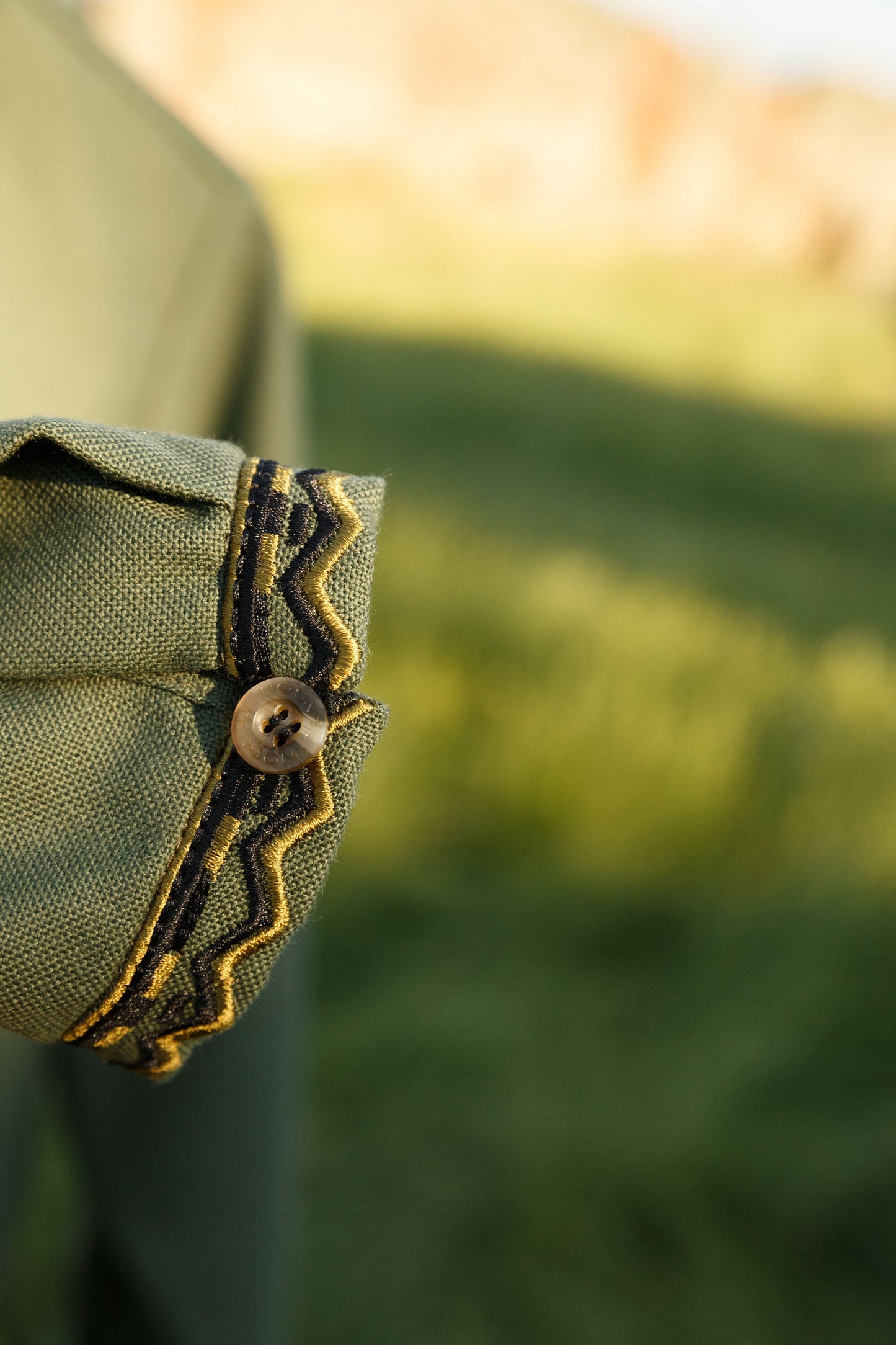 Ukrainian embroidery detail on men's Vyshyvanka military-style shirt sleeve, handmade cotton fabric.