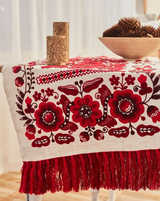 Ukrainian embroidered wedding rushnyk with red cross-stitched floral motifs on linen, symbolizing traditional blessings.