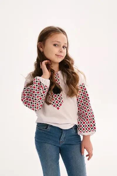Girl wearing Ukrainian embroidered blouse in Vyshyvanka style with traditional patterns.