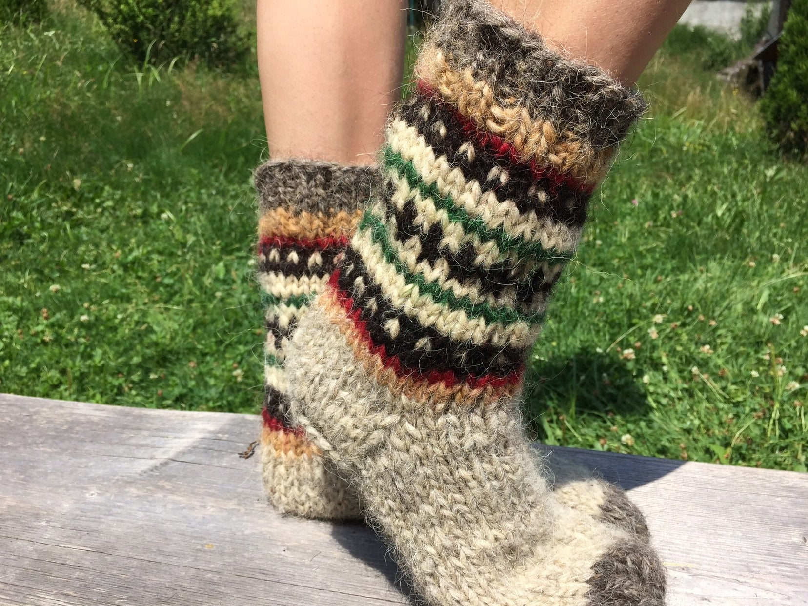 Hand knitted wool socks with colorful patterns, made in Ukraine, providing warmth and natural foot massage, ideal gift for loved ones.