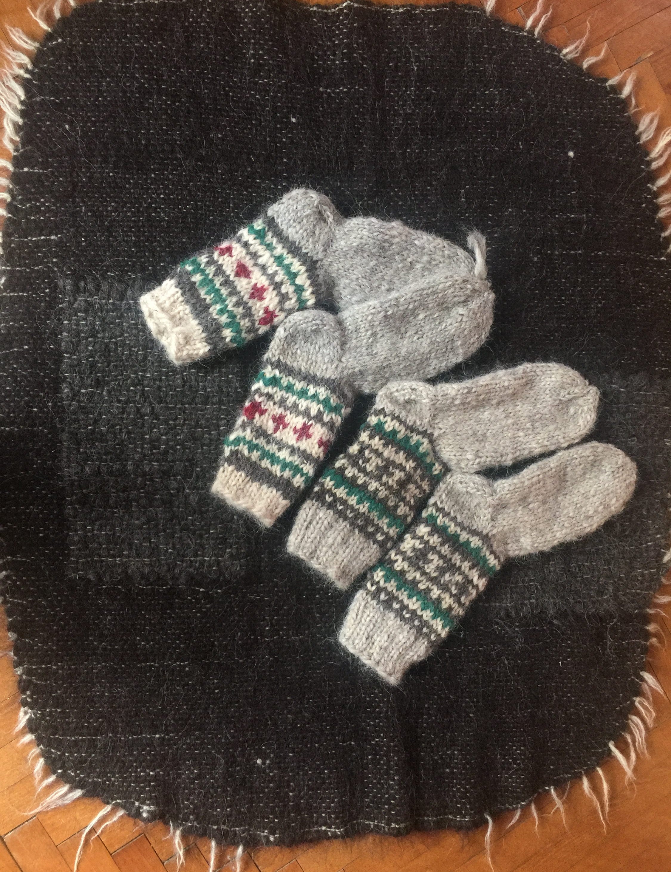 Hand-knitted wool socks with traditional patterns, made in Ukraine, displayed on a woven black cloth.