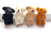 Four tiny hand-sewn fuzzy teddy bears in black, white, brown, and tan with moveable limbs, perfect for decoration or gifts.