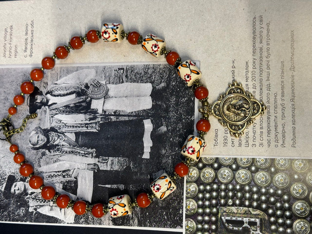 Harmony of Nature necklace with white clay beads and jasper, displayed over a cultural text background.
