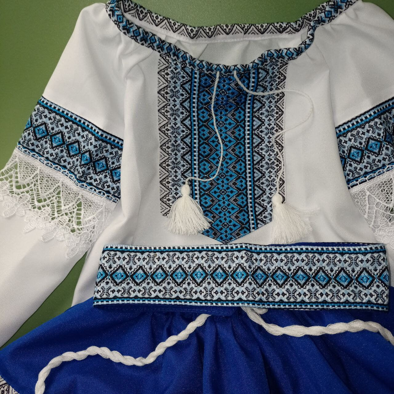 Ukrainian Hutsul folk costume for girls in blue, featuring woven designs and lace. Includes blouse, skirt, and belt.