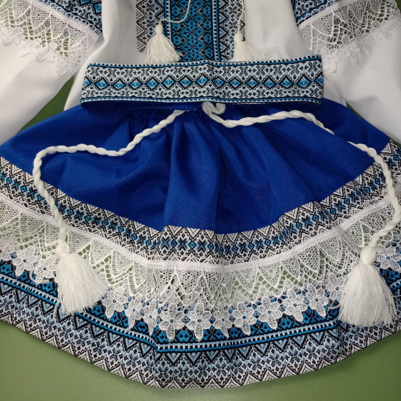Blue Ukrainian Hutsul folk costume for girls with lace detail, featuring a woven skirt and belt. Ideal for cultural events.