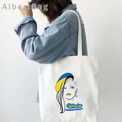 Woman holding Ukrainian Patriotic Grocery Tote Bag with colorful design