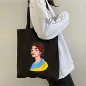Ukrainian Patriotic Grocery Tote Bag with colorful design worn by person in gray sweater