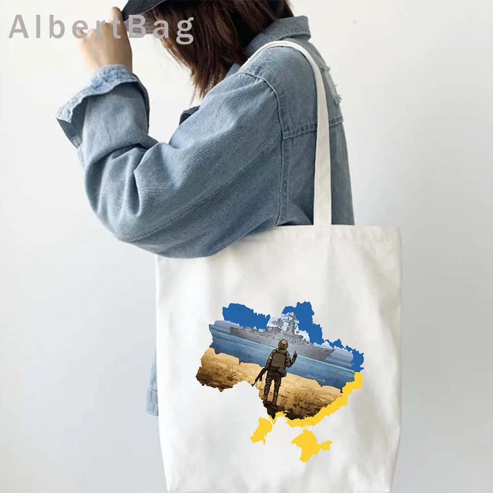 Woman carrying Ukrainian patriotic cotton tote bag with map design