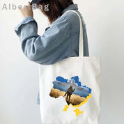 Woman carrying Ukrainian patriotic cotton tote bag with map design