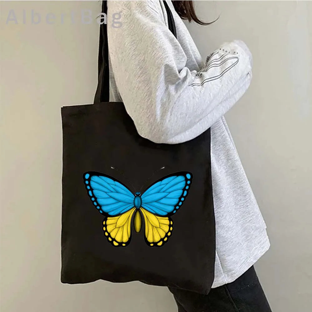 Woman holding Ukrainian patriotic grocery tote bag with butterfly design
